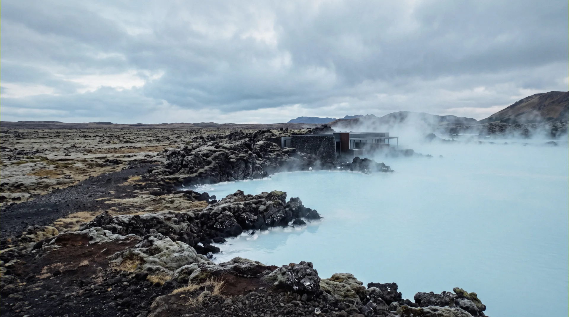 Steam drifting over the milky blue water and lava banks of the Blue Lagoon, Iceland hot springs on the Reykjanes peninsula