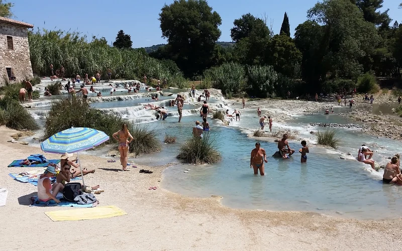 Stone bungalows and a thermal stream at Agriturismo Le Cascatelle beside the Saturnia hot springs, Tuscany