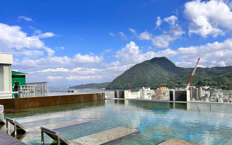 Rooftop infinity onsen pool above Beppu Bay at AMANEK Beppu YULA-RE, Beppu onsen, Oita, Japan
