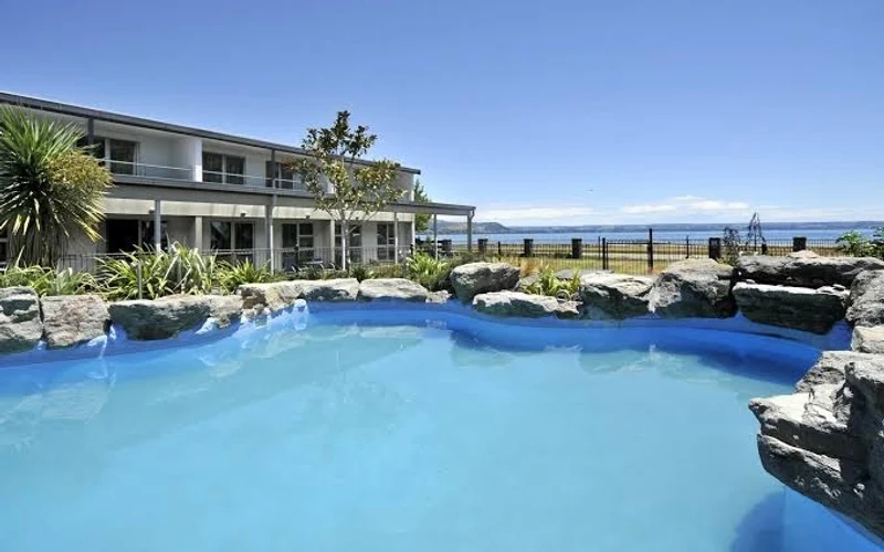 Wai Ora Lakeside Spa Resort unheated pool and lake frontage at Holdens Bay, Rotorua hot springs hotels, New Zealand